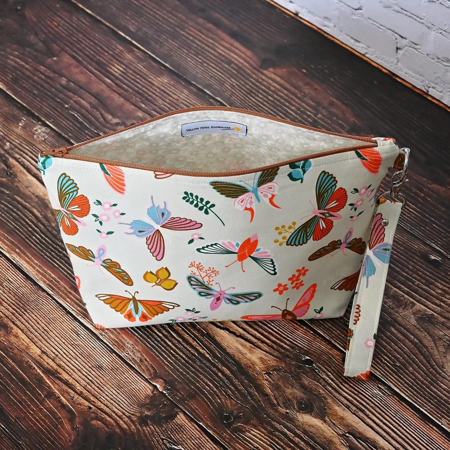 Gorgeous cream pouch with removable strap. Made from a striking butterfly patterned cotton and lined in a pretty cream floral, both by Ruby Star Society. Made in Canada by Yellow Petal Handmade.