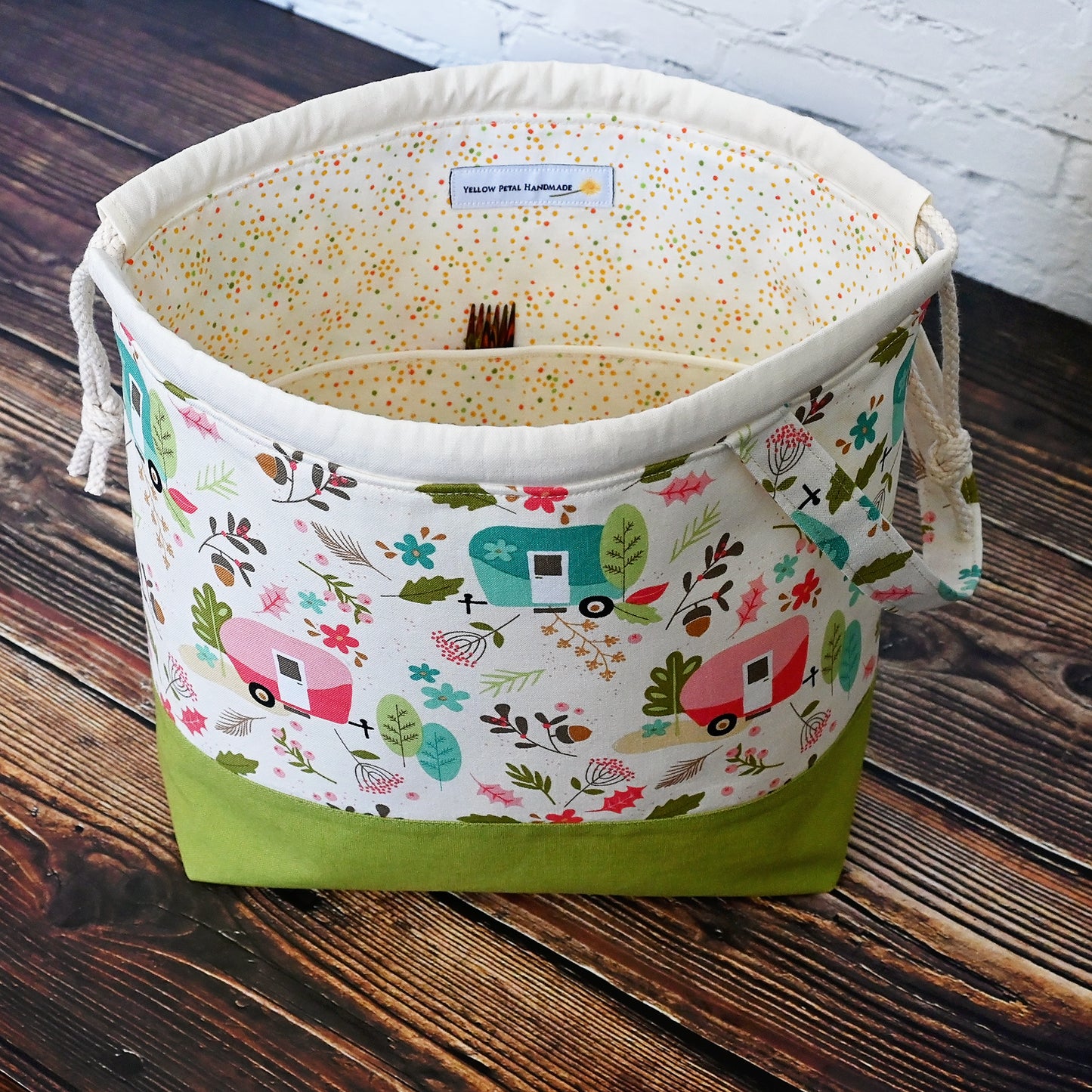 Cream and lime green camping themed project bag with a drawstring closure and carry handle. The interior has a fun spotty print and pockets for storage. Made in Nova Scotia, Canada by Yellow Petal Handmade.