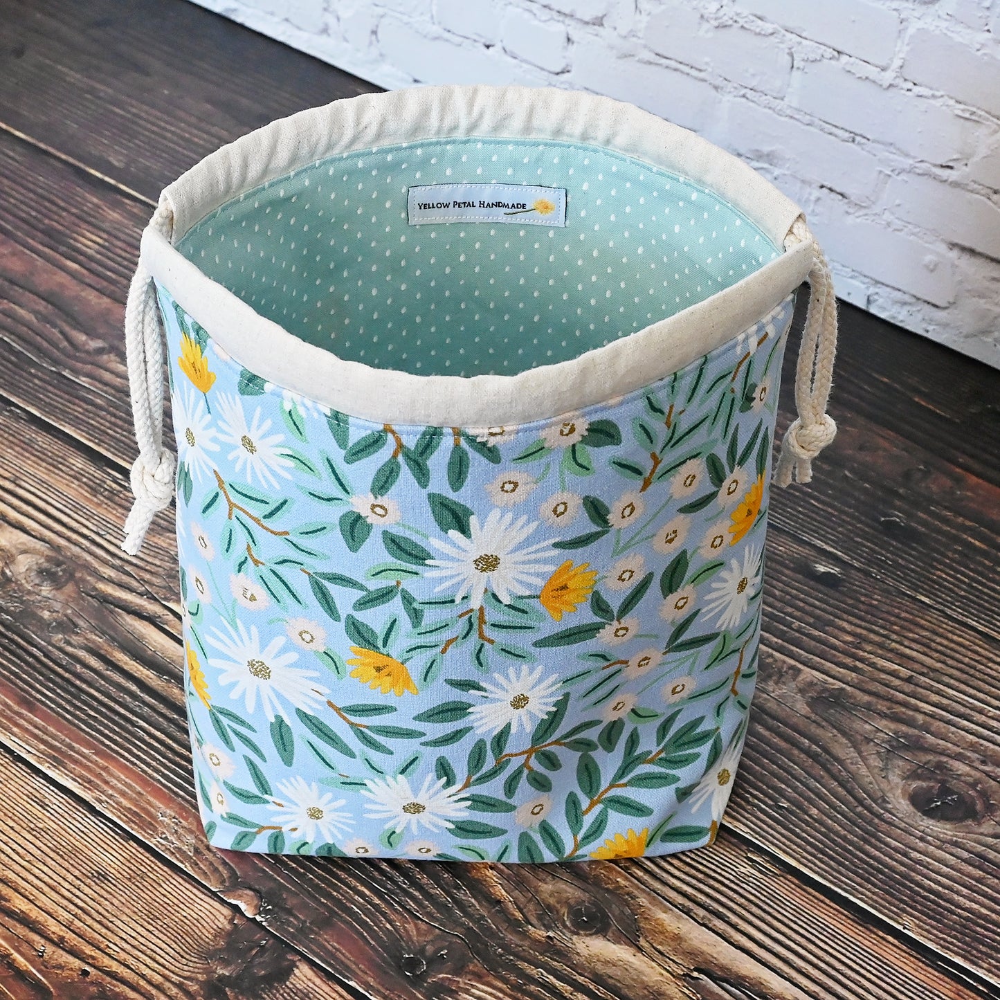 Pretty blue floral project bag made from a lovely canvas by Rifle Paper Co. Lined in a pretty aqua and closes securely with a double drawstring. Perfect for small knitting or crochet projects. Made in Canada by Yellow Petal Handmade.