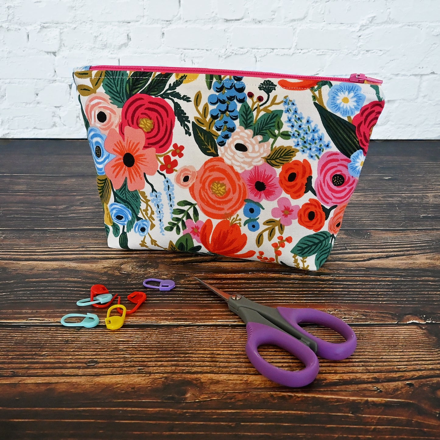 Pretty floral pouch in Rifle Paper's Garden Party fabric. This pouch has a lovely raspberry coloured lining and zipper to match. It's perfect for carrying all of your small accessories.