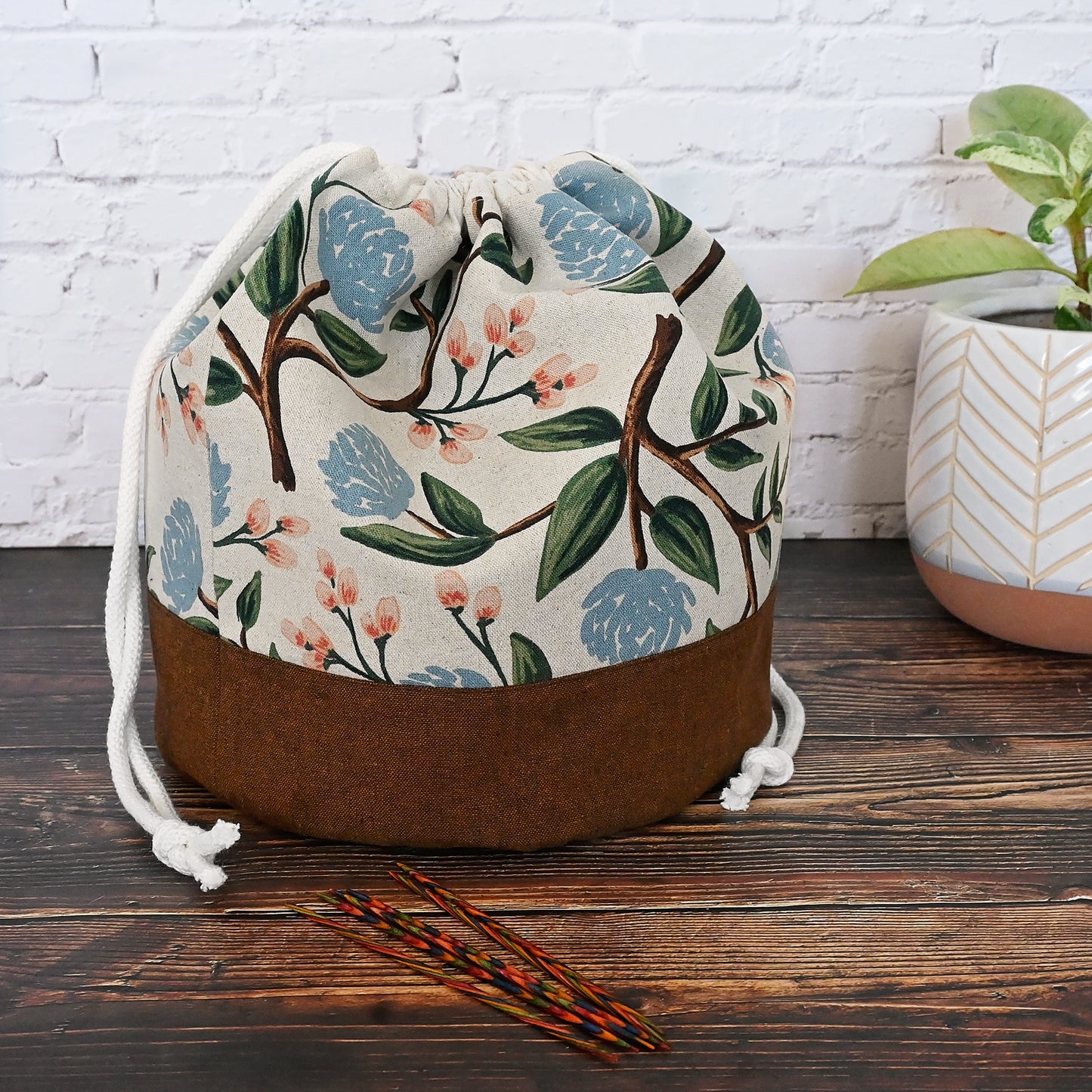 Lovely natural canvas and linen bucket style project bag made from Rifle Paper Co's Peony fabric. Lined in an unbleached cotton and has multiple slip pockets in a pretty blush and while floral. This bag closes securely with a double drawstring and has a quilted bottom for stability as well as a fun design feature. Made in Nova Scotia Canada by Yellow Petal Handmade.