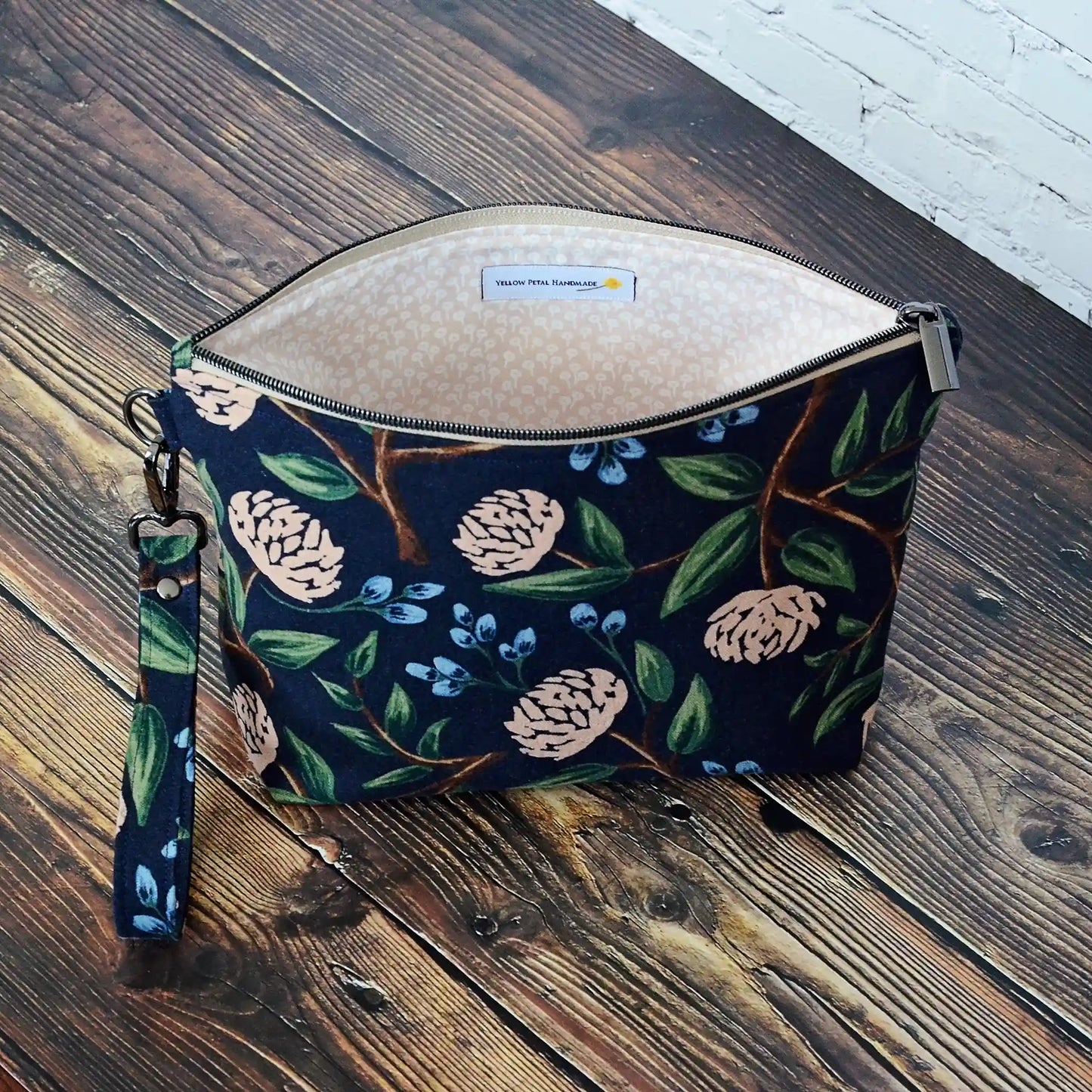 Navy canvas pouch made from peonies fabric from Rifle Paper Co and lined with a pale blush and white flowered cotton. Comes with removable strap. Made in Canada by Yellow Petal Handmade.