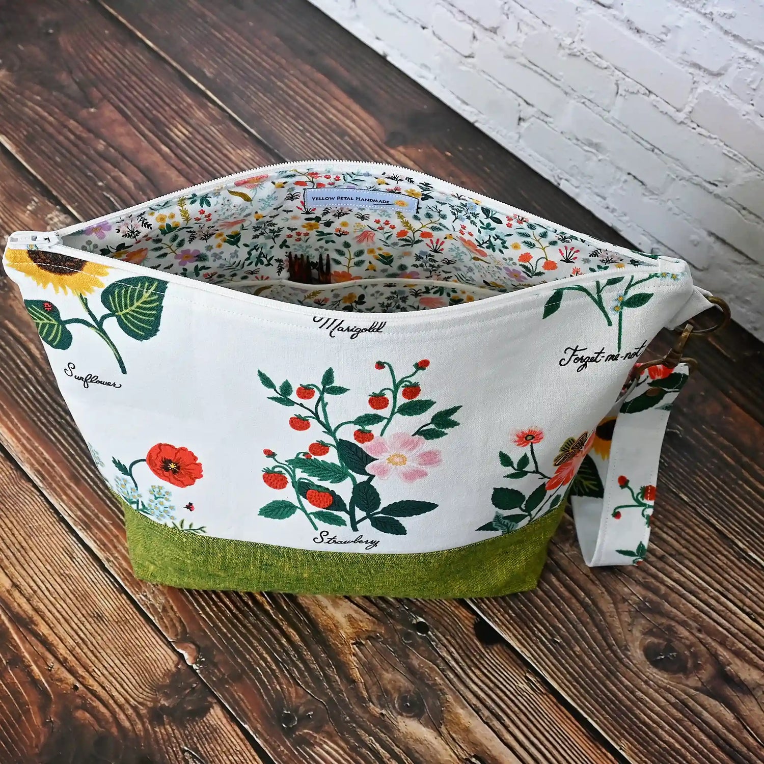 Stunning white canvas floral project bag, paired with a lovely green linen.  This bag has pockets, closes with a zipper and has a lovely removable wrist strap.  Made in Canada by Yellow Petal Handmade.