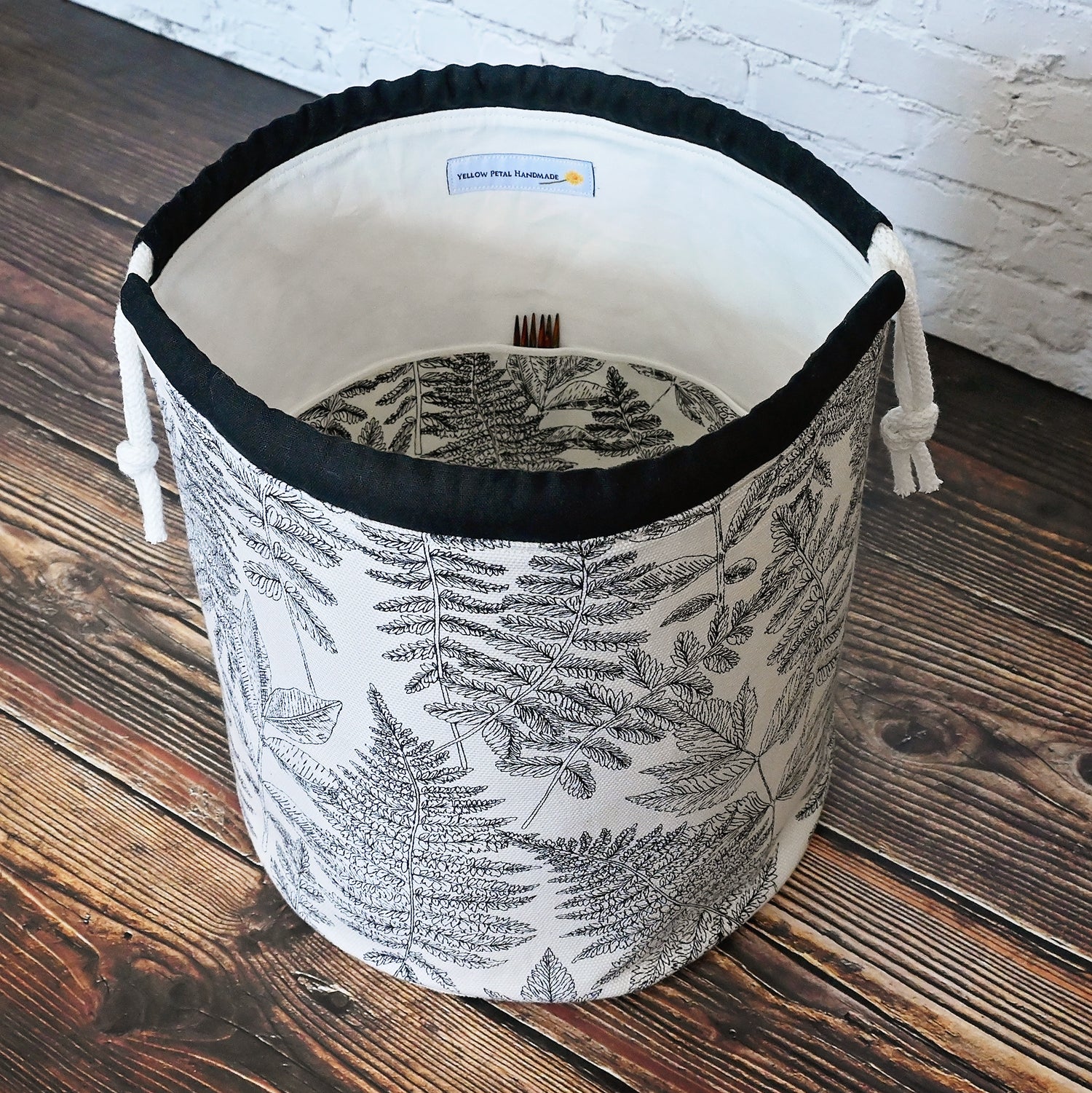 Striking fern pattern bucket bag in cream and black.  Made from the Green Thumb collection by Art Gallery Fabrics, this canvas bucket bag features lots of pockets and a quilted bottom for design and function.  Closes securely with a double drawstring.  Made in Canada by Yellow Petal Handmade.