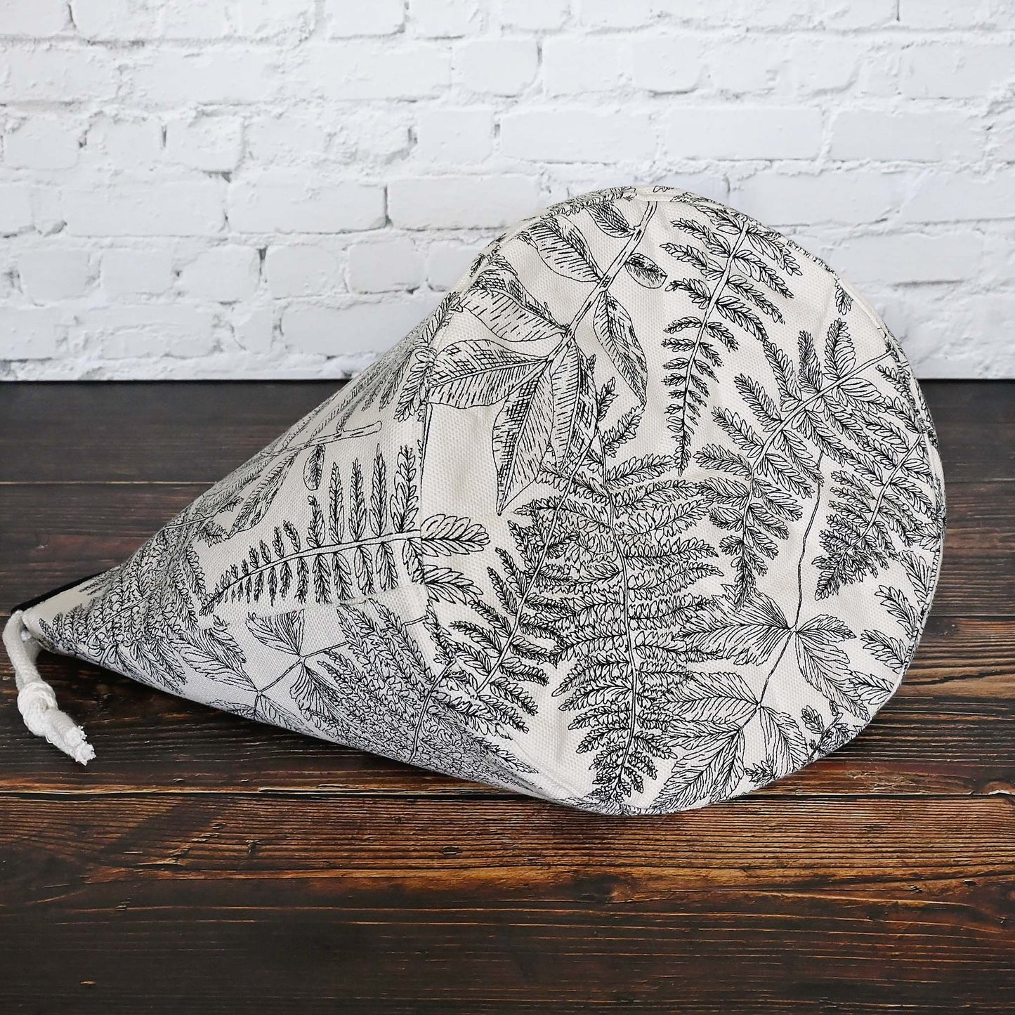 Striking fern pattern bucket bag in cream and black.  Made from the Green Thumb collection by Art Gallery Fabrics, this canvas bucket bag features lots of pockets and a quilted bottom for design and function.  Closes securely with a double drawstring.  Made in Canada by Yellow Petal Handmade.