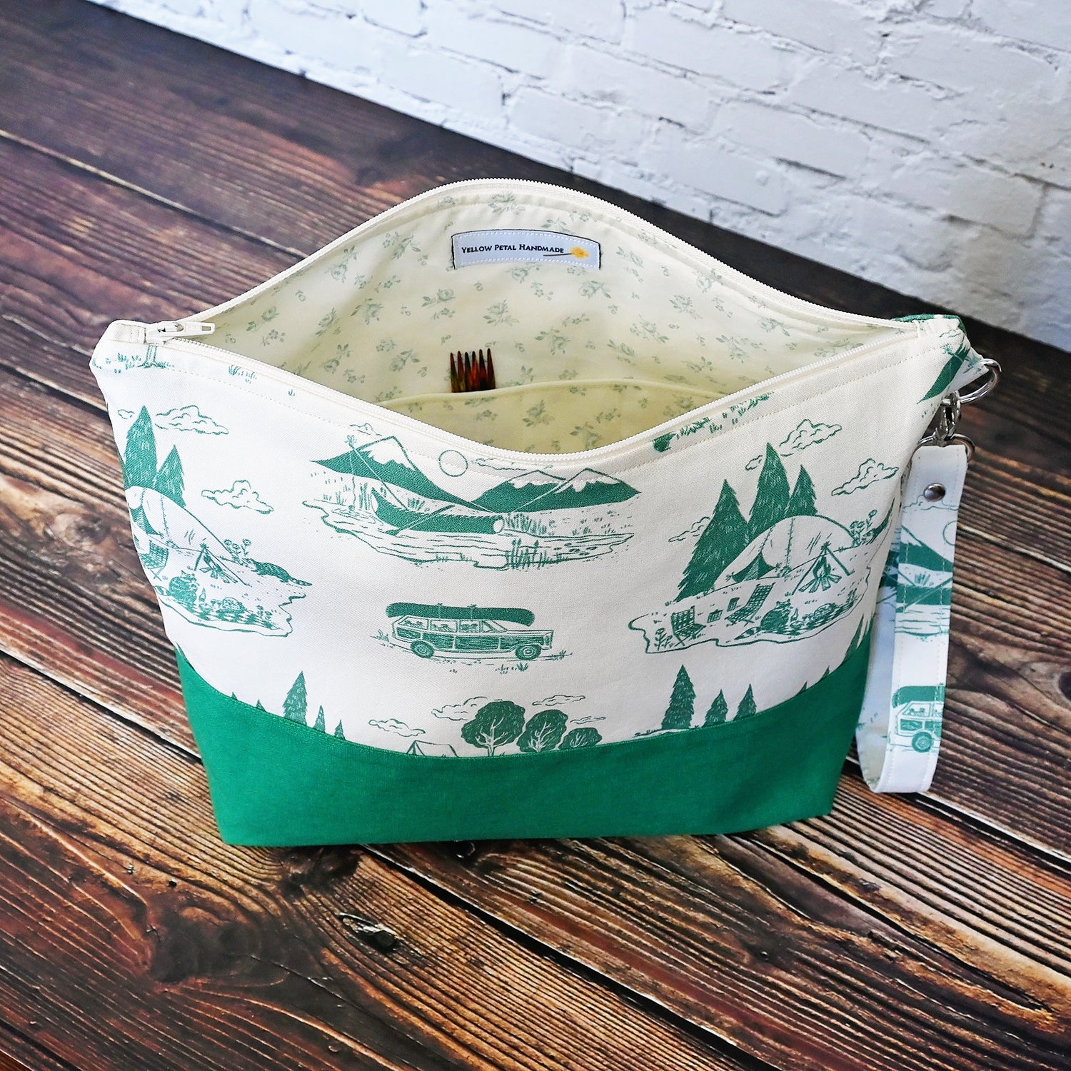 Classic Green and Cream project bag.  Made from a cream and green camping print and paired with a green linen on the exterior.  Lined in a pretty cream and green floral.  This bag comes with a removable wrist strap, and has multiple pockets for storage on the go.  Made in Canada by Yellow Petal Handmade.