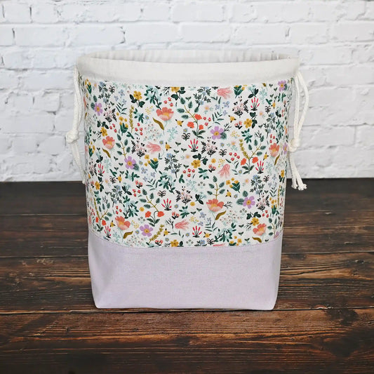 Pretty white floral and mauve linen drawstring project bag in Rifle Paper Co's Curio fabric.  The interior is a pretty mauve fabric with pockets.  Made in Nova Scotia, Canada by Yellow Petal Handmade.