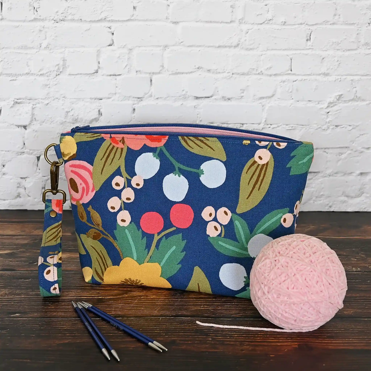 Blue floral canvas zippered pouch with removable wrist strap, lined in a pretty pink cotton.  Handmade in Canada by Yellow Petal Handmade.