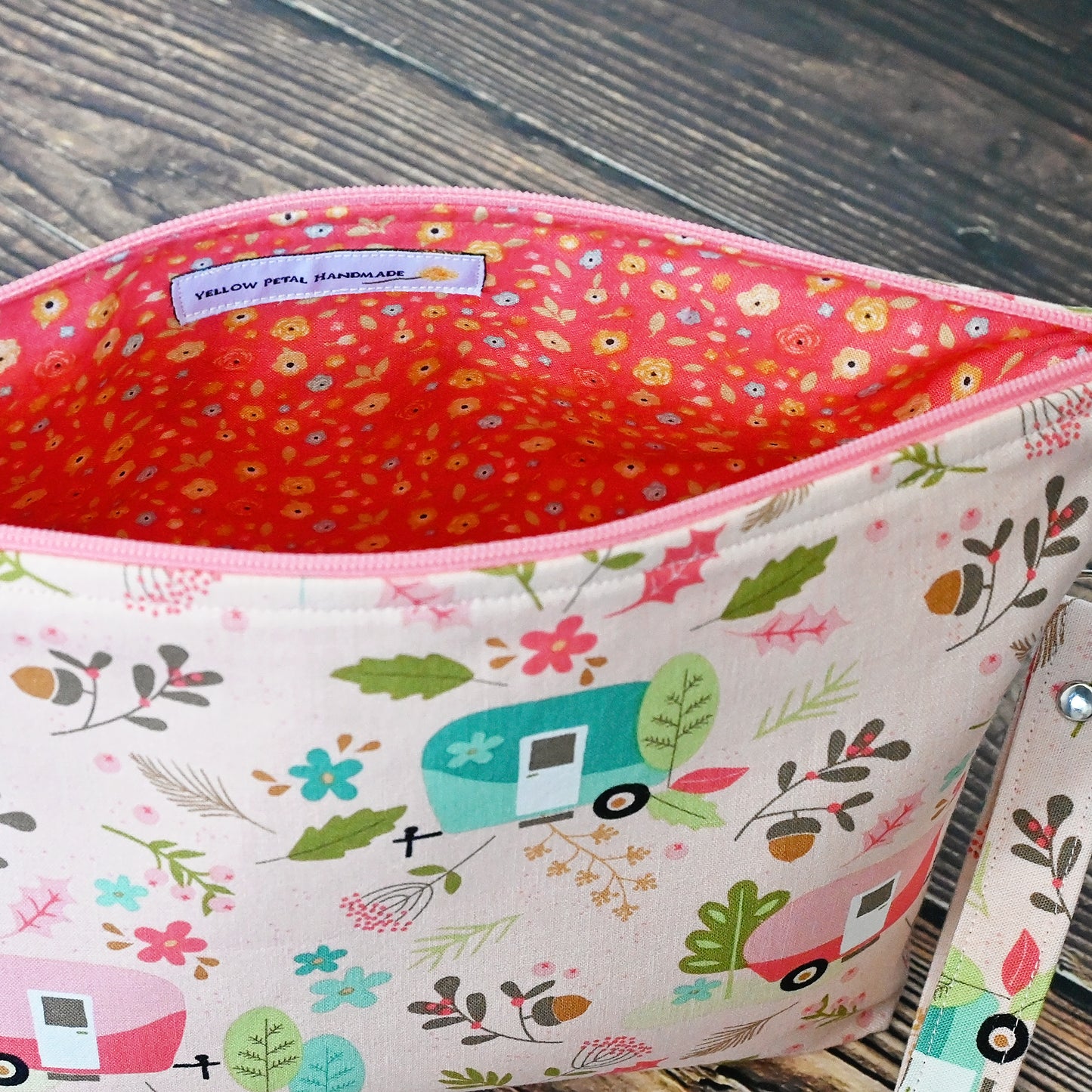 Pretty pink camper themed pouch with removable wrist strap.  This pouch doesn't have pockets, but is lined in a lively coordinating floral.  Made in Canada by Yellow Petal Handmade.