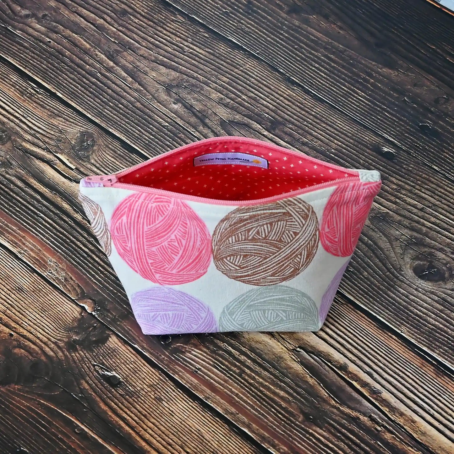 Cute Yarn Balls canvas pouch measuring 8" wide by 5" tall and with a 3.5" boxed bottom.   Fabric has cute yarn balls with metallic copper detailing.  Made in Canada by Yellow Petal Handmade.