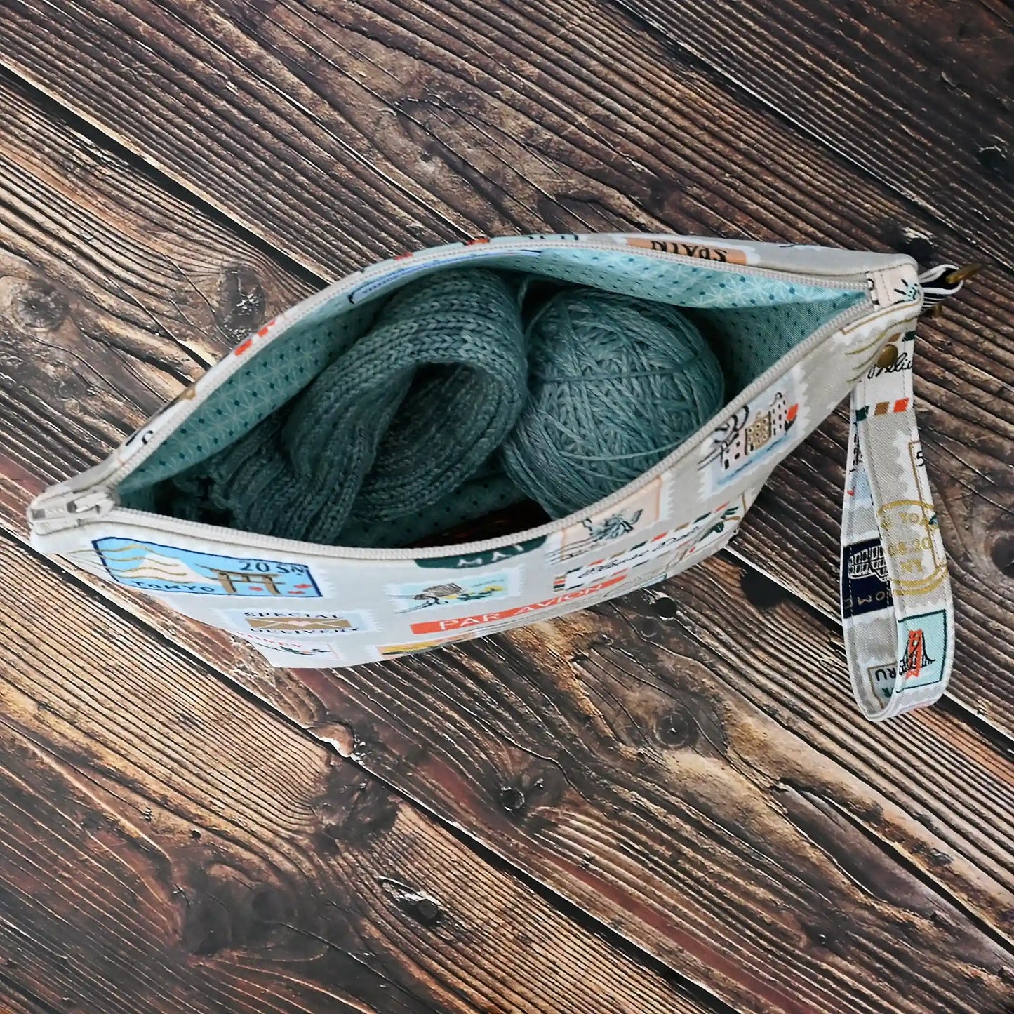 Fun stamp themed mini project bag in Rifle Paper Co canvas.  This bag features metallic gold details on a stamp printed canvas and is lined in a pretty aqua cotton.  Comes with a removable wrist strap.  Made in Canada by Yellow Petal Handmade.