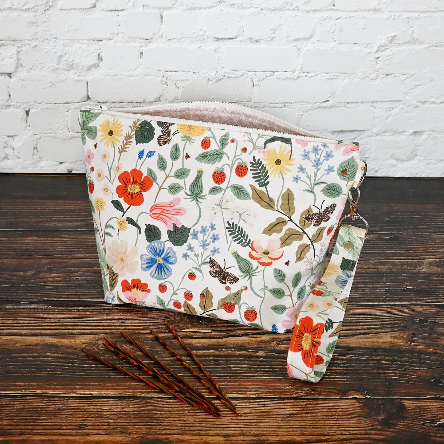 Pretty floral pouches in Rifle Paper Co's Strawberry Fields fabric.  Lined with a pretty pink and white floral lining.  These bags come with a removable wrist strap and a perfect for carrying small projects.