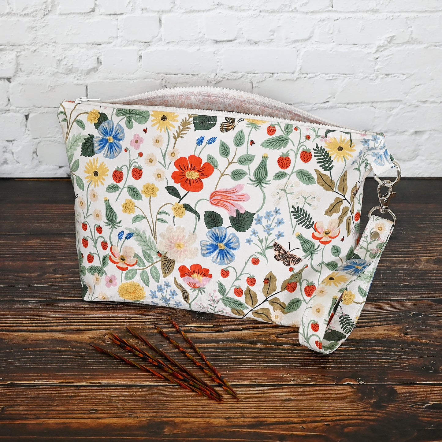 Pretty floral pouches in Rifle Paper Co's Strawberry Fields fabric.  Lined with a pretty pink and white floral lining.  These bags come with a removable wrist strap and a perfect for carrying small projects.