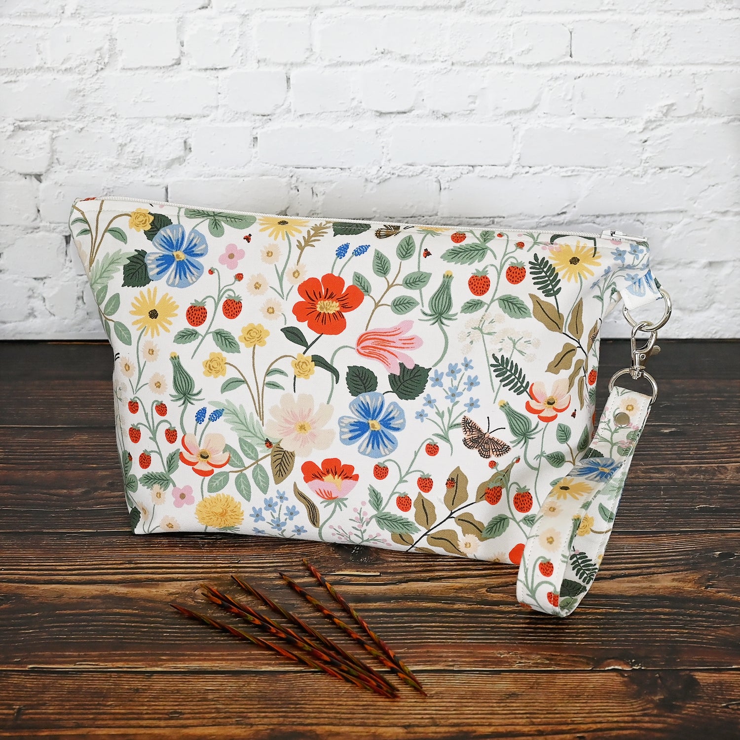 Pretty floral pouches in Rifle Paper Co's Strawberry Fields fabric.  Lined with a pretty pink and white floral lining.  These bags come with a removable wrist strap and a perfect for carrying small projects.