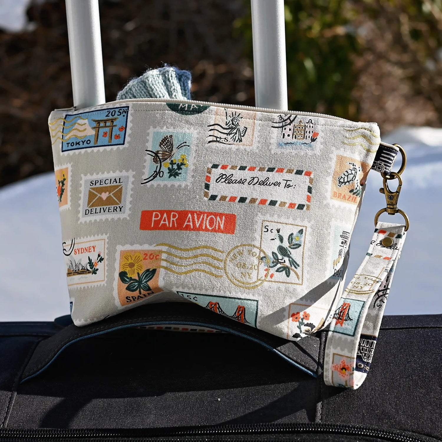 Fun stamp themed mini project bag in Rifle Paper Co canvas.  This bag features metallic gold details on a stamp printed canvas and is lined in a pretty aqua cotton.  Comes with a removable wrist strap.  Made in Canada by Yellow Petal Handmade.