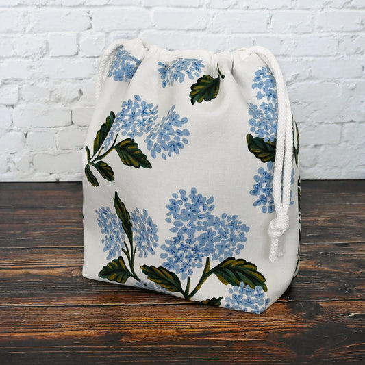 Lovely white and blue floral cotton project bag for your knitting or crochet projects.  This is a drawstring bag and is available with or without pockets.  It is made from a lovely Hydrangea fabric from Rifle Paper Co and is lined in a whimsical blue cotton.  Closes with a double drawstring for added security.  Made in Canada by Yellow Petal Handmade.