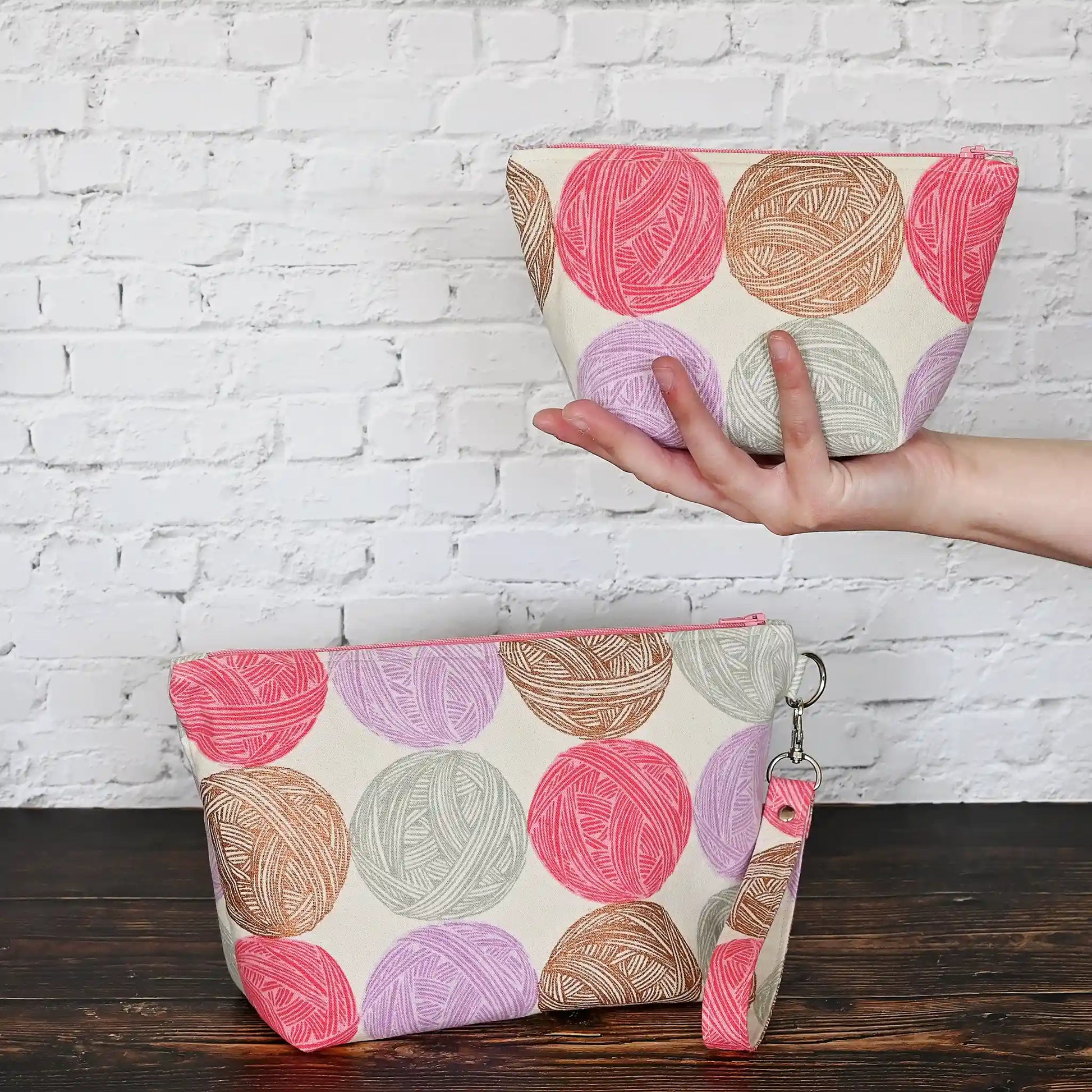 Cute Yarn Balls canvas pouch measuring 8" wide by 5" tall and with a 3.5" boxed bottom.   Fabric has cute yarn balls with metallic copper detailing.  Made in Canada by Yellow Petal Handmade.