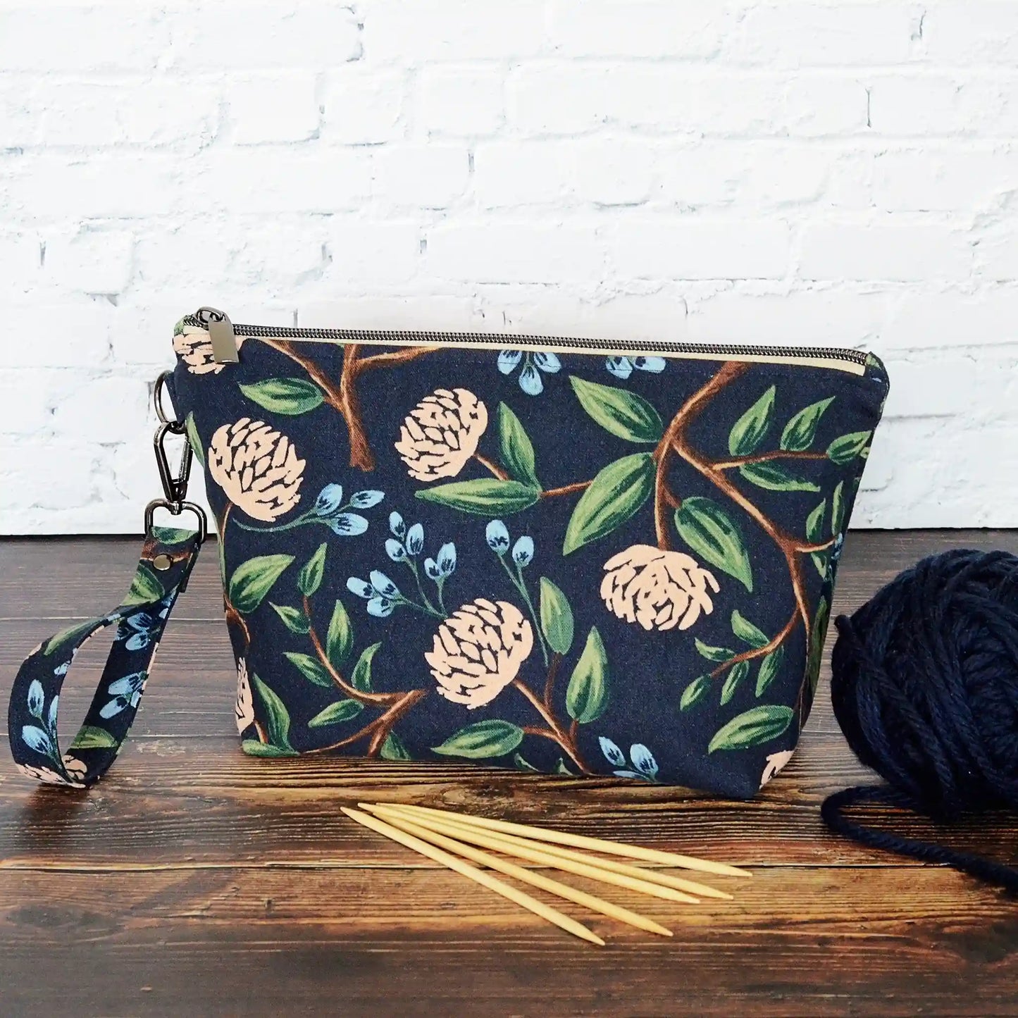 Navy canvas pouch made from peonies fabric from Rifle Paper Co and lined with a pale blush and white flowered cotton.  Comes with removable strap.  Made in Canada by Yellow Petal Handmade.