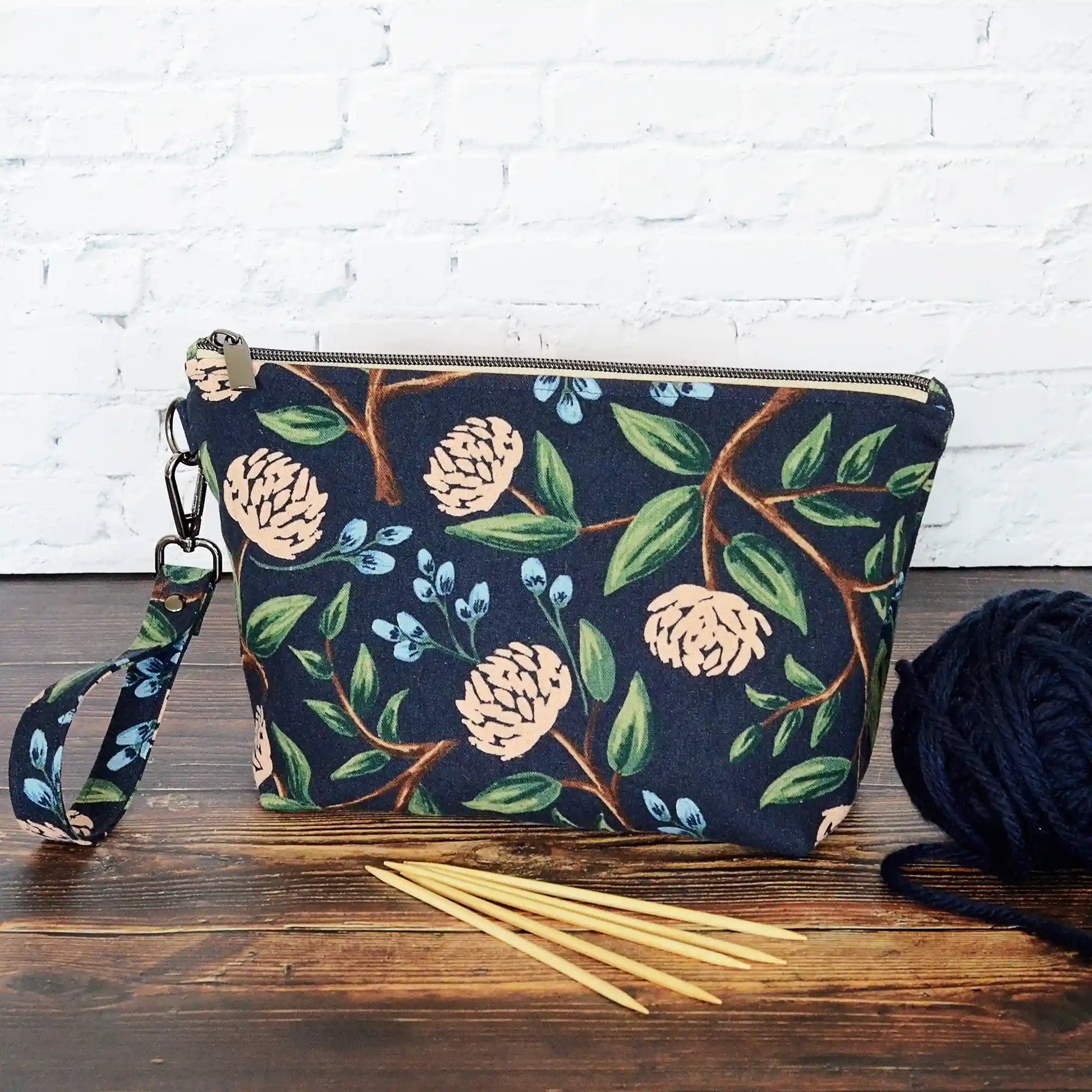 Navy canvas pouch made from peonies fabric from Rifle Paper Co and lined with a pale blush and white flowered cotton.  Comes with removable strap.  Made in Canada by Yellow Petal Handmade.